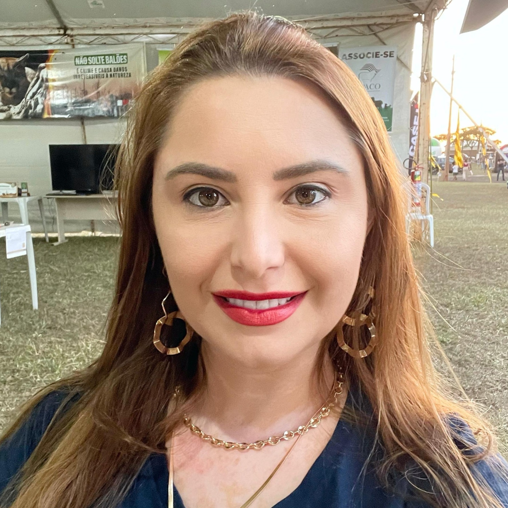 Foto de Stela Virgilio, com cabelos longos e ruivos, sorrindo e olhando diretamente para a câmera.